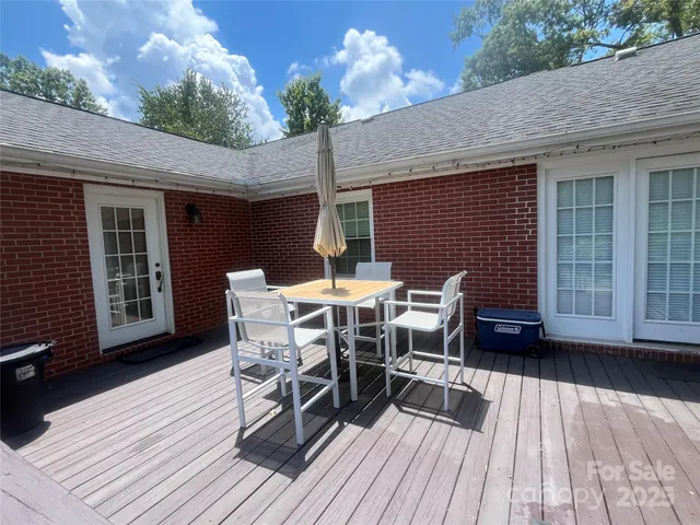 a view of a patio with table and chairs with wooden floor and fence
