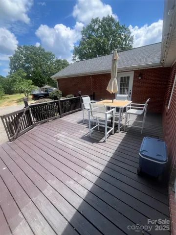 a view of a roof deck with table and chairs couches with wooden floor