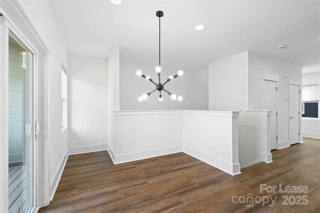 a view of a room with wooden floor and a ceiling fan