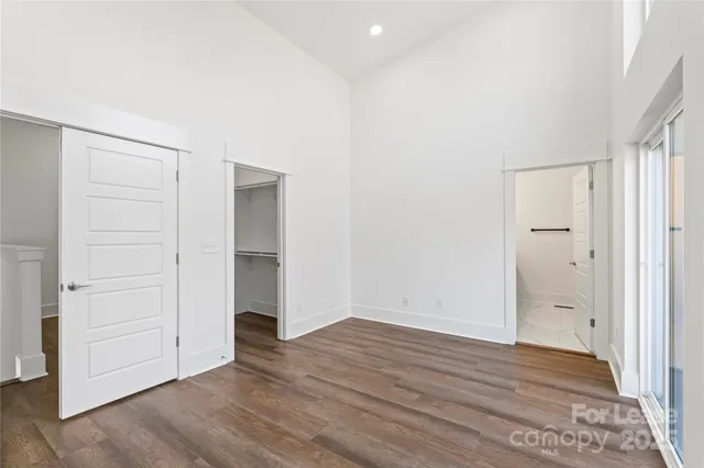 an empty room with wooden floor & closet area