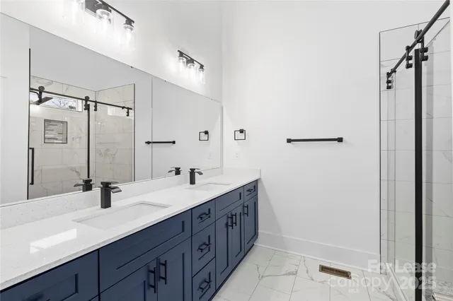a bathroom with a double vanity sink a mirror and shower