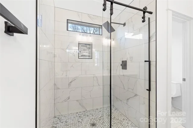 a bathroom with a shower and a glass door