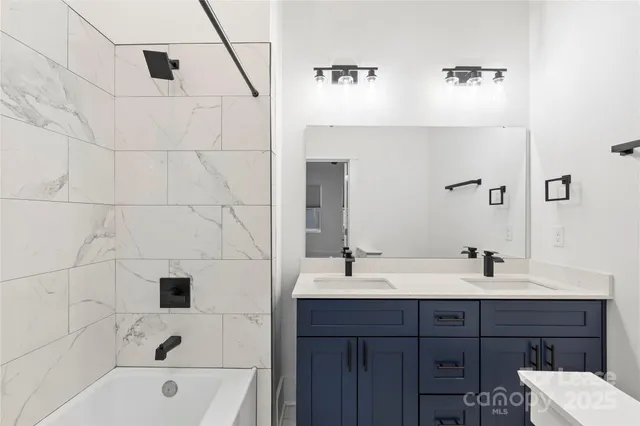 a bathroom with a tub sink and mirror