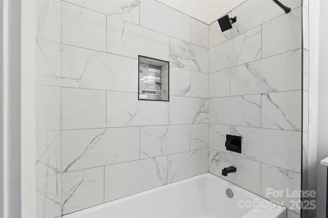 a bathroom with a bathtub and shower