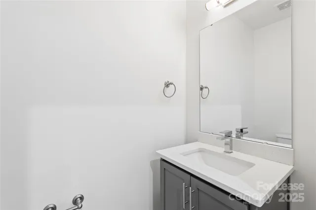 a bathroom with a sink vanity and a mirror