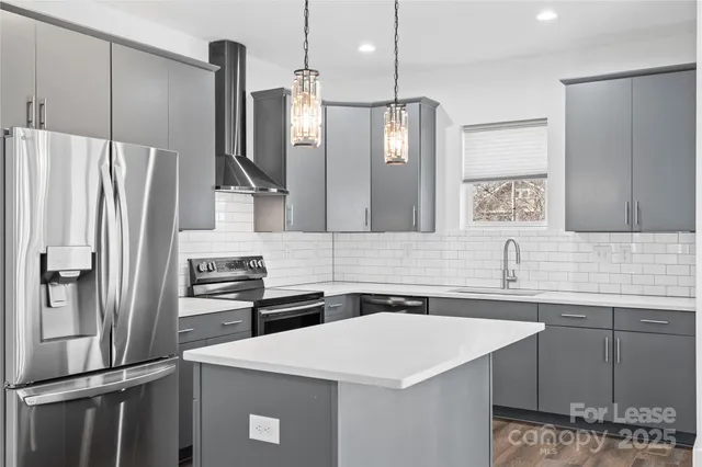 a kitchen with stainless steel appliances a sink and a refrigerator