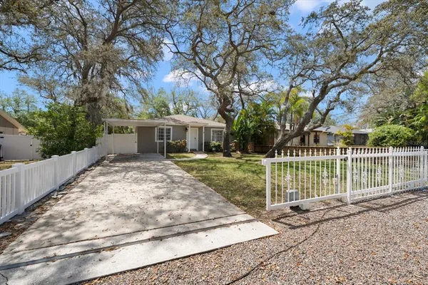 a view of a house with a backyard and a tree