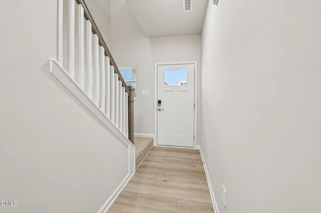 a kitchen with stainless steel appliances granite countertop white cabinets and a stove a oven with wooden floor