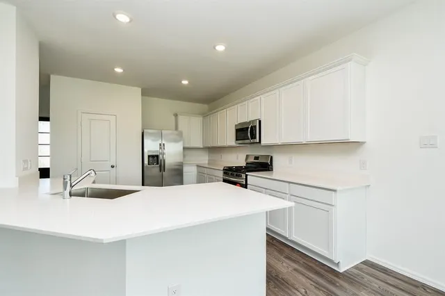 a kitchen with stainless steel appliances a stove sink and cabinets