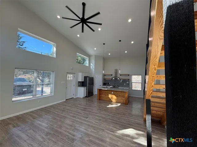 a view of a living room and kitchen with furniture wooden floor a rug