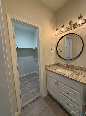 a bathroom with a granite countertop sink and a mirror