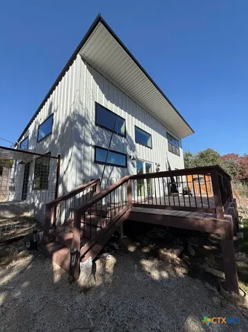 a view of wooden house with a wooden deck