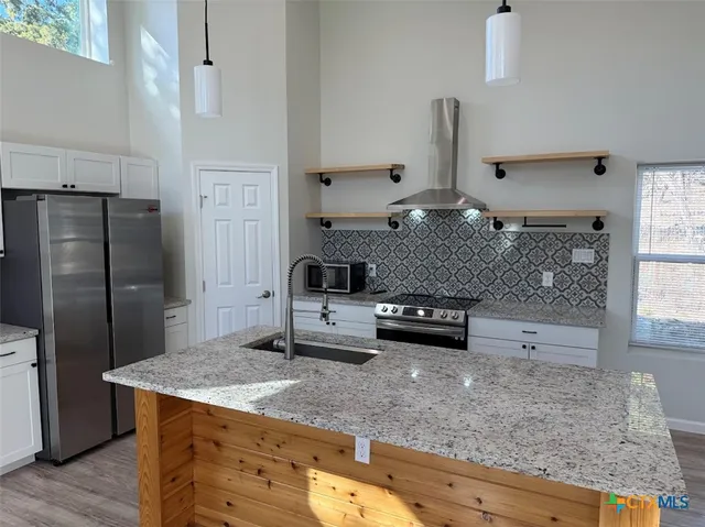 a kitchen with stainless steel appliances granite countertop a sink stove and refrigerator