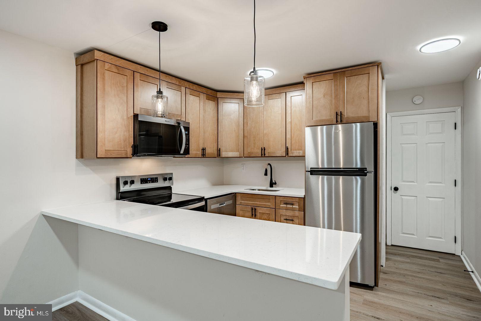 a kitchen with stainless steel appliances a refrigerator sink and microwave