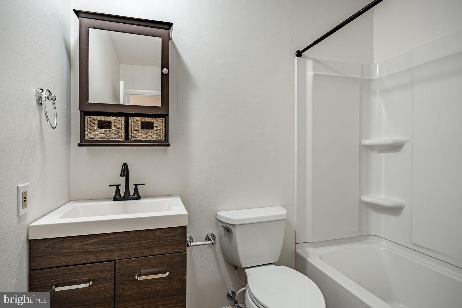 300 North Penn Street, Unit W9 West Chester, PA 19380 - Photo 7 of 9 a bathroom with a toilet a sink and mirror