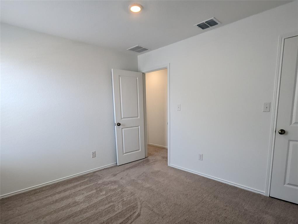 152 Avre Loop Kyle, TX 78640 - Photo 20 of 24 A well-proportioned interior space offers a neutral palette and plush carpeting.