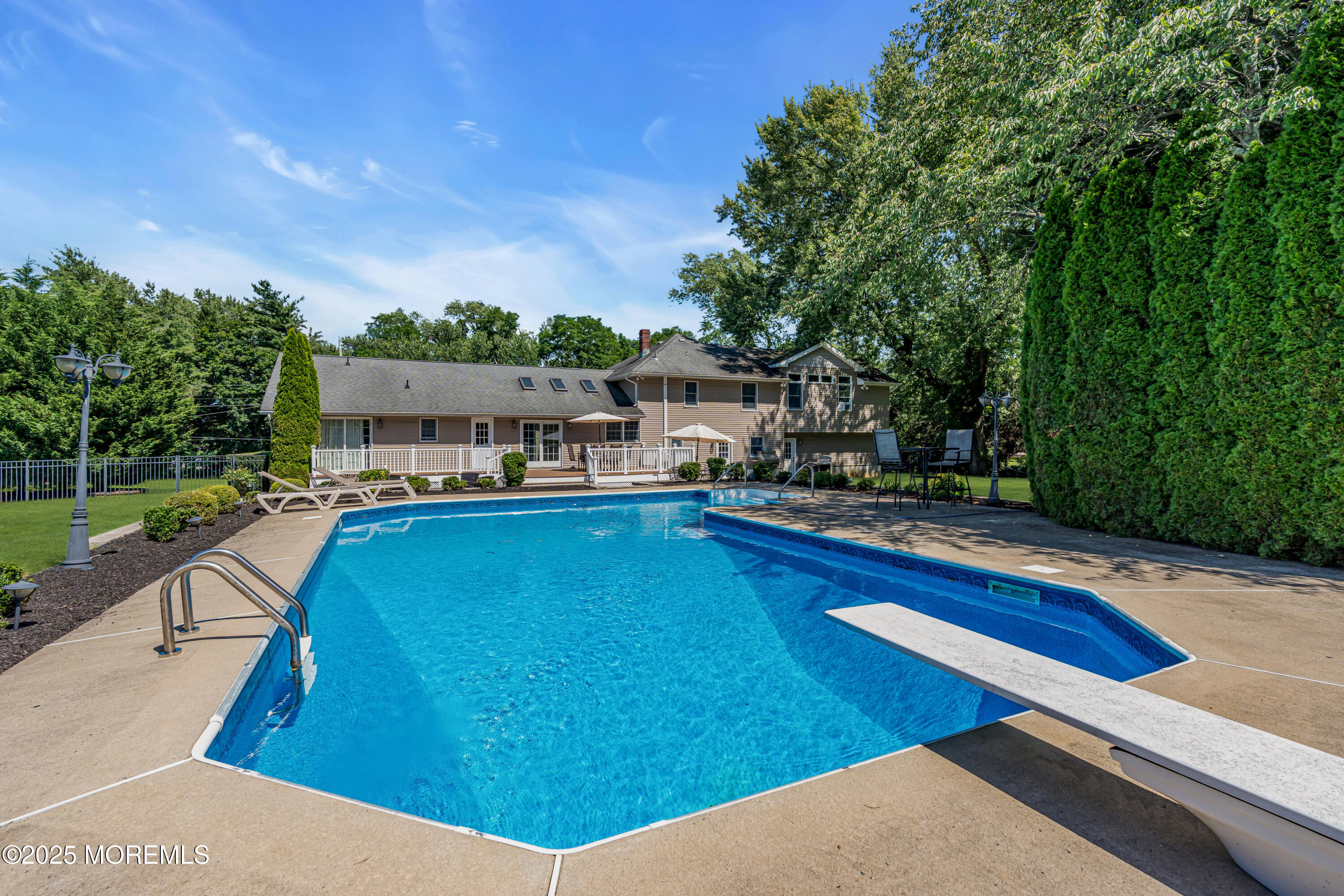 40 Centerville Road Holmdel, NJ 07733 - Photo 56 of 60 a view of a swimming pool with lawn chairs plants and large trees