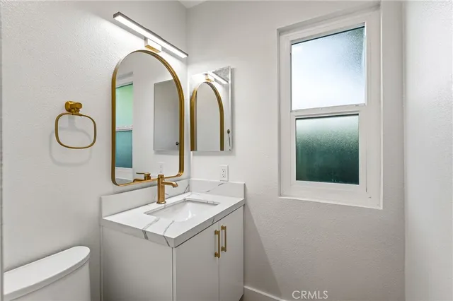 a bathroom with a granite countertop sink and a mirror