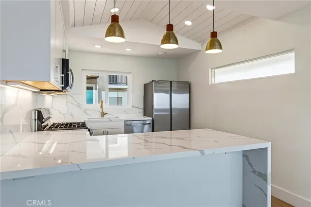 a large kitchen with stainless steel appliances kitchen island a chandelier