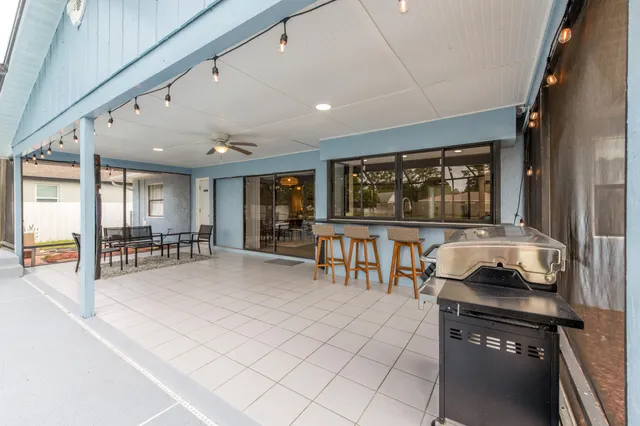 a living room with furniture a flat screen tv and floor to ceiling window