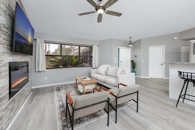 a living room with furniture a flat screen tv and a fireplace