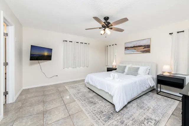 a bedroom with a large bed and a flat screen tv