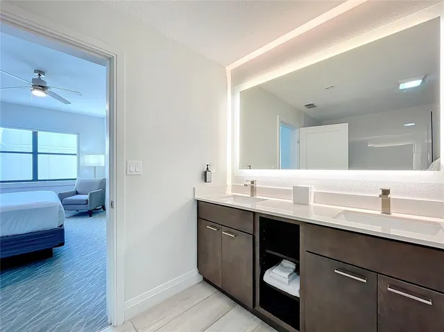 a en suite bathroom with a double vanity sink and a mirror