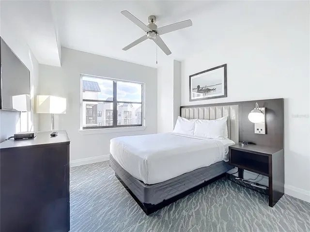 a bedroom with a bed table and window