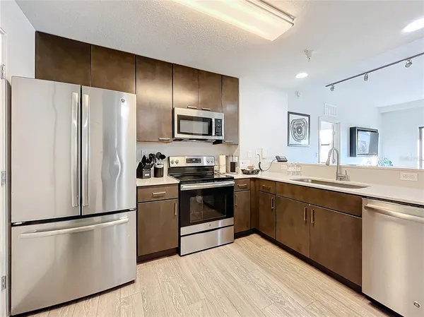 a kitchen with stainless steel appliances a refrigerator sink and microwave
