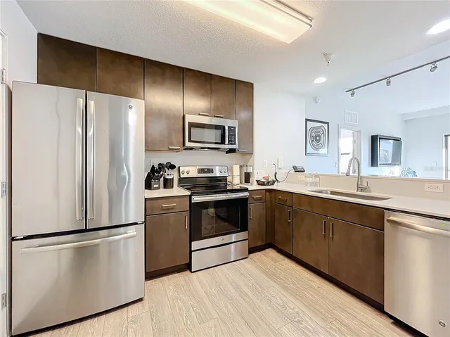 a kitchen with stainless steel appliances a refrigerator sink and microwave