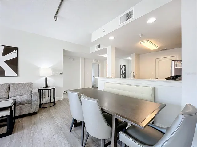 a view of a a dining room with furniture window and wooden floor
