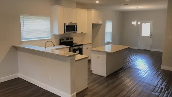 a view of an empty room and wooden floor