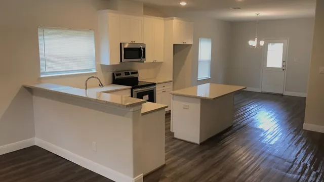 a kitchen with cabinets and wooden floor