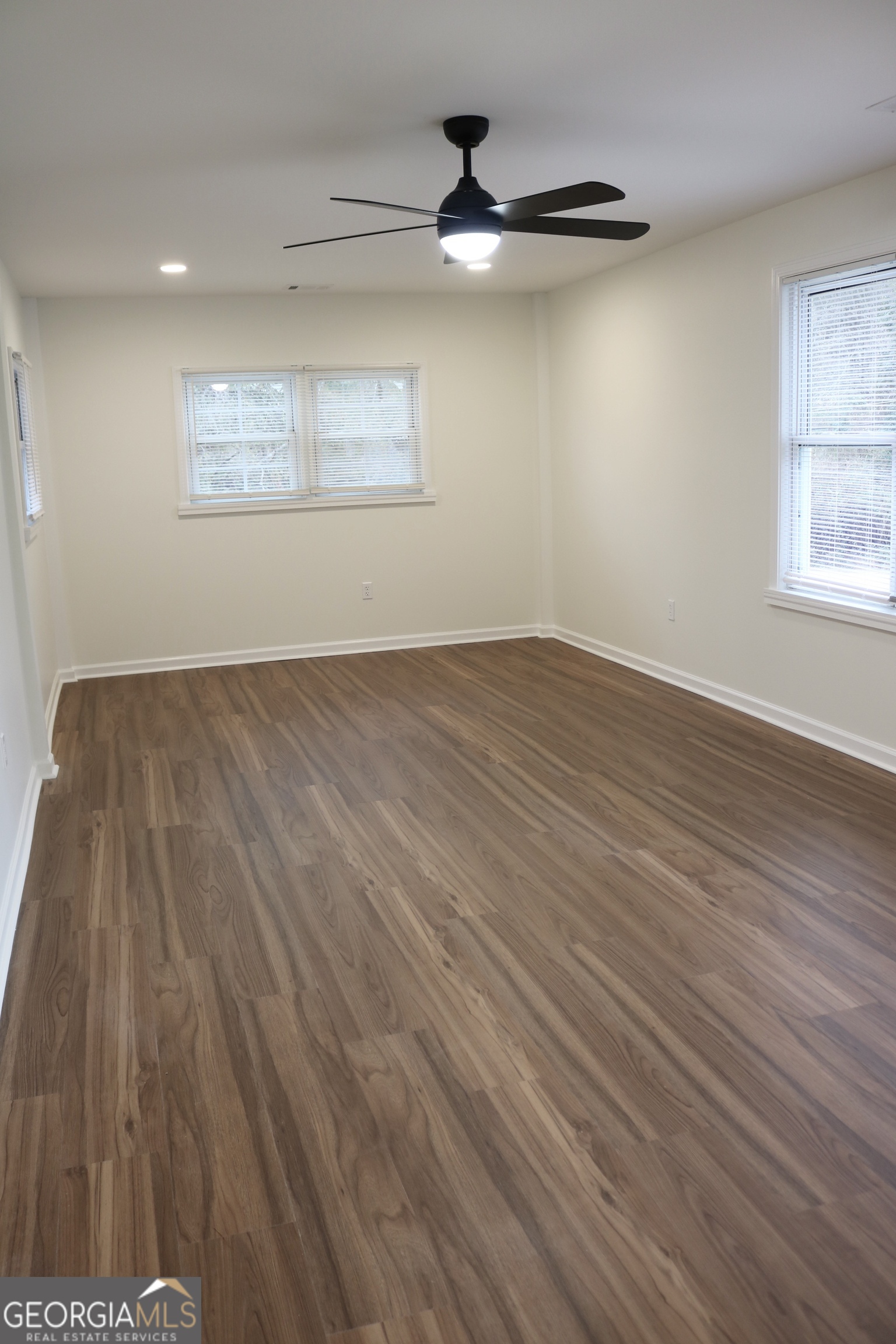 135 Chase Road LaGrange, GA 30241 - Photo 7 of 20 an empty room with wooden floor chandelier fan and windows