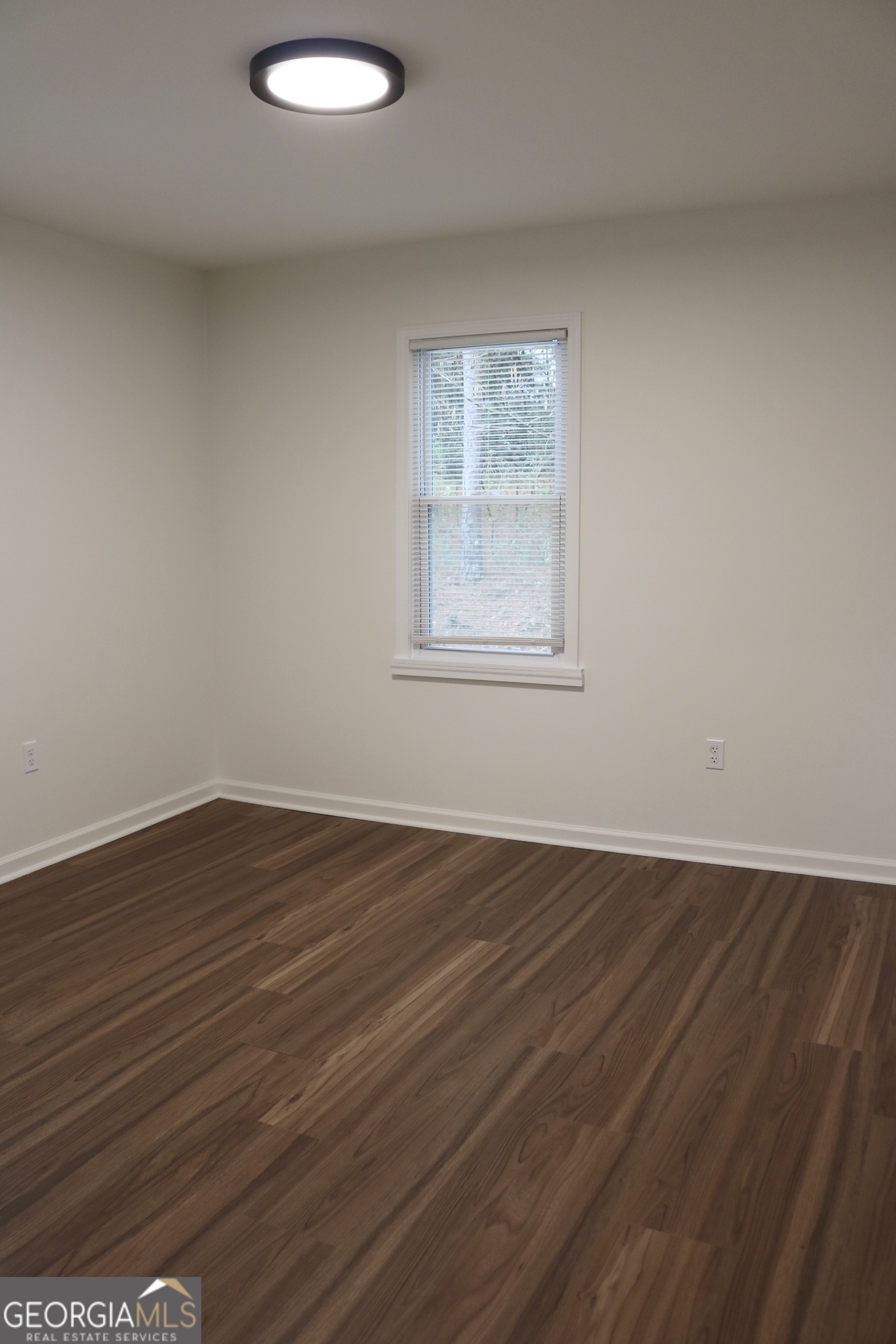 135 Chase Road LaGrange, GA 30241 - Photo 9 of 20 an empty room with wooden floor and windows