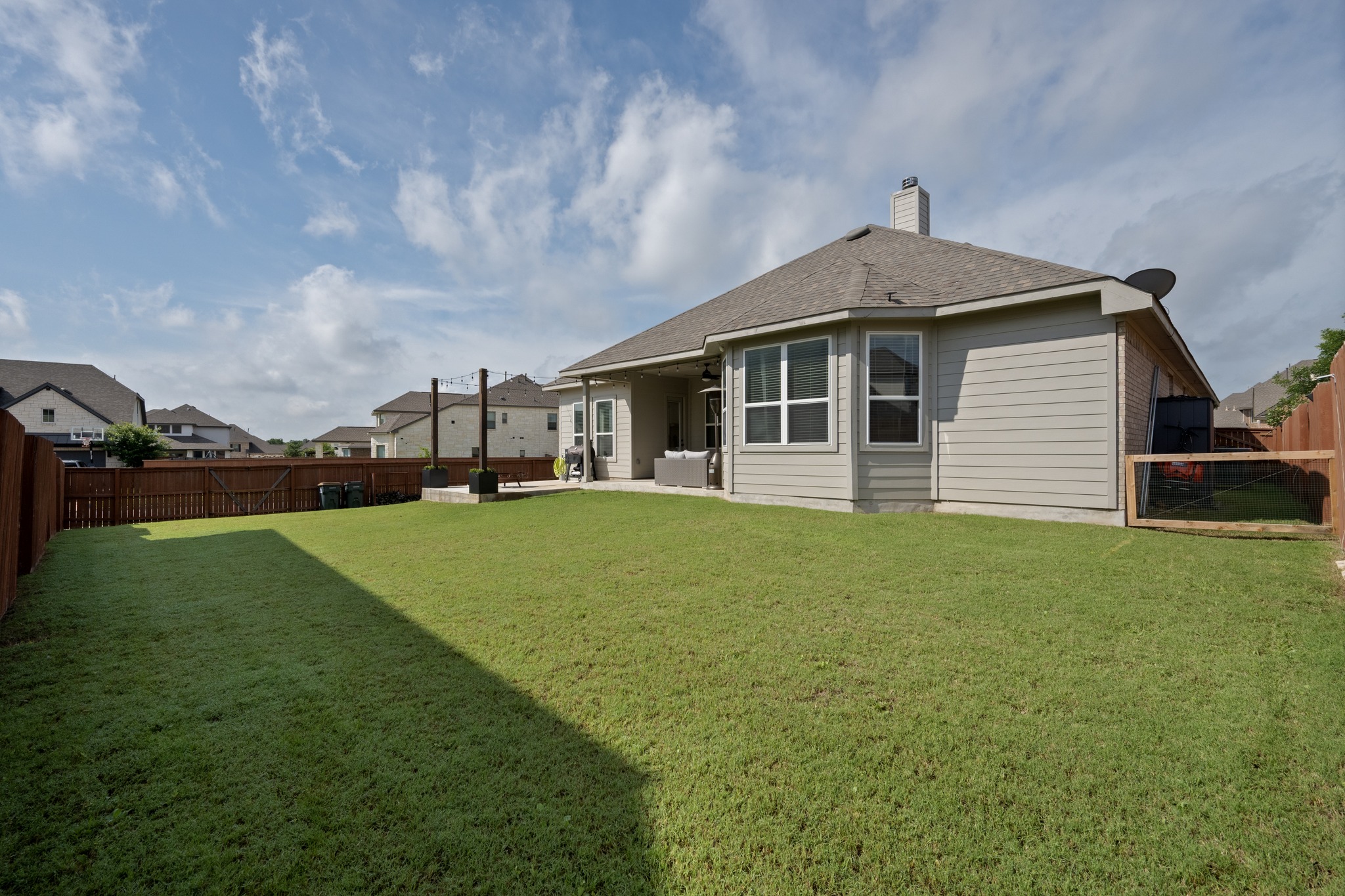 2100 Highland Ridge Road Georgetown, TX 78628 - Photo 29 of 30 A fenced backyard offers ample green space and a covered patio perfect for outdoor enjoyment.