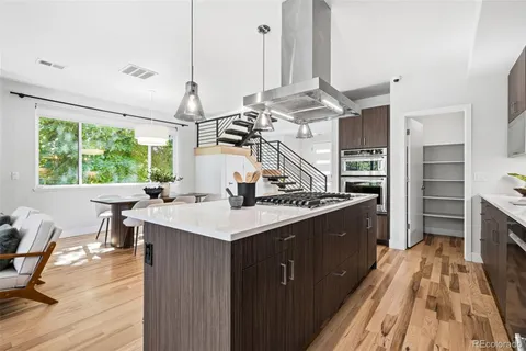 a kitchen with a sink appliances and wooden floor