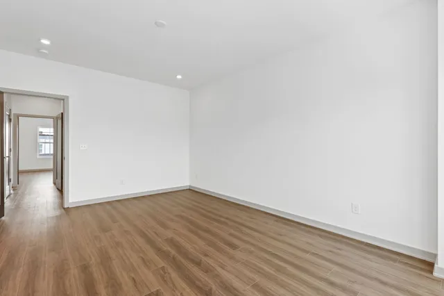 a view of a livingroom with wooden floor and a ceiling fan