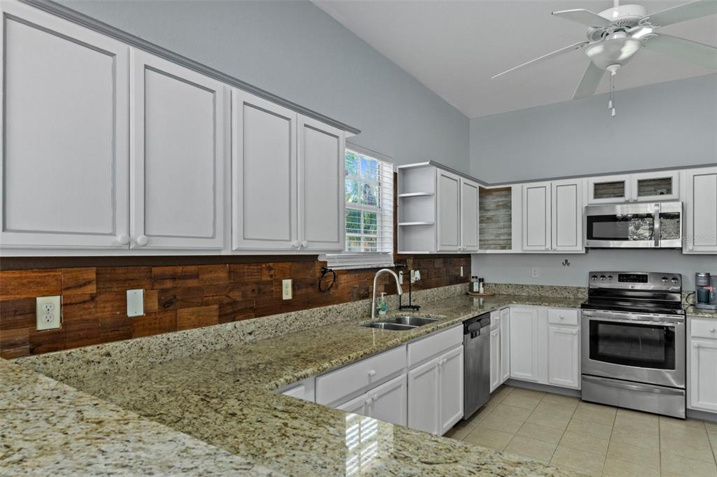 8229 Gulf Way Hudson, FL 34667 - Photo 16 of 35 a kitchen with granite countertop a sink stainless steel appliances and cabinets