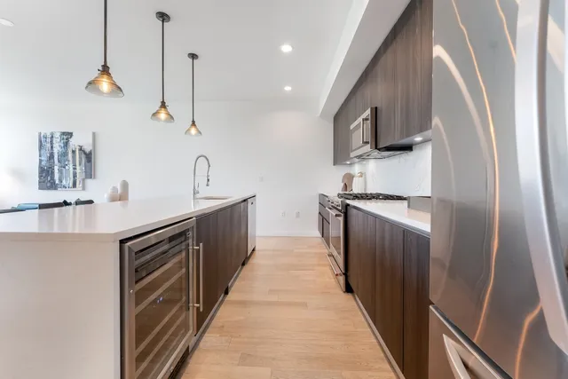 a kitchen with stainless steel appliances granite countertop a sink a stove and a refrigerator