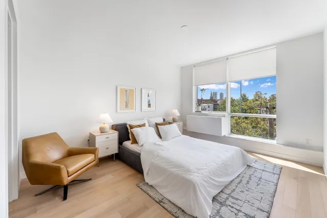 a bedroom with a bed and a large window