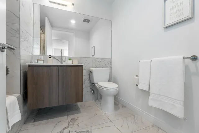 a bathroom with a toilet sink and mirror
