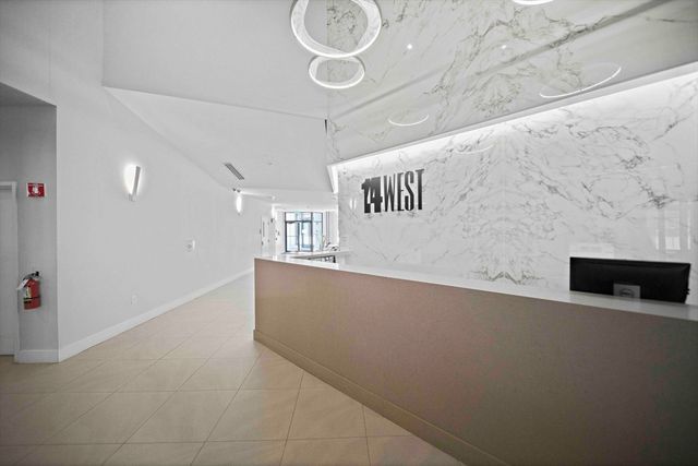 a living room with furniture a flat screen tv and kitchen view
