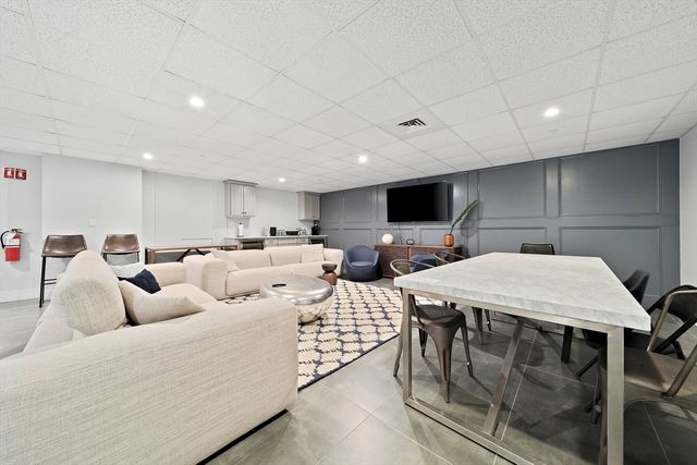 a living room with furniture a flat screen tv and kitchen view