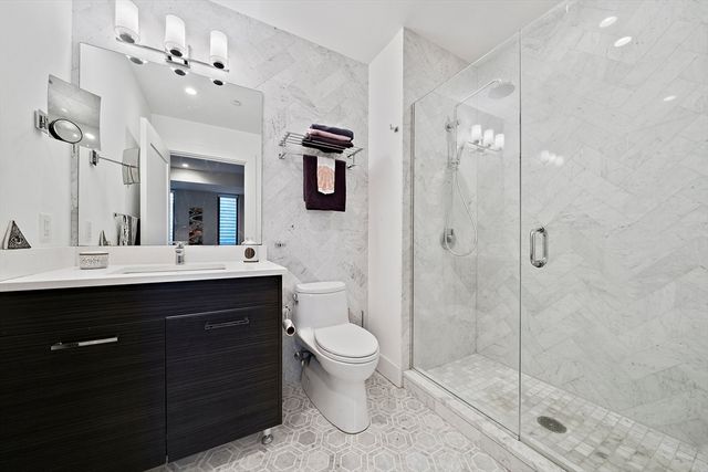 a bathroom with a sink a toilet a mirror and shower