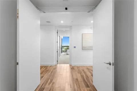 a view of a room with wooden floor and a hallway