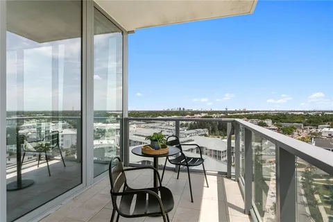 a living room with a table chairs and a kitchen view