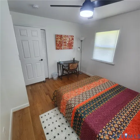 a bedroom with a bed and a lamp on dresser
