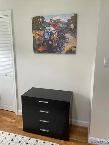 a bedroom with a bed and a painting on the wall