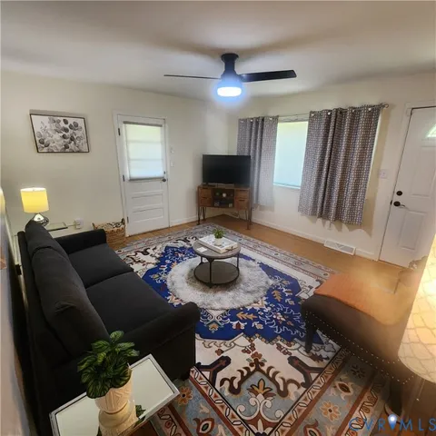a living room with furniture and a wooden floor